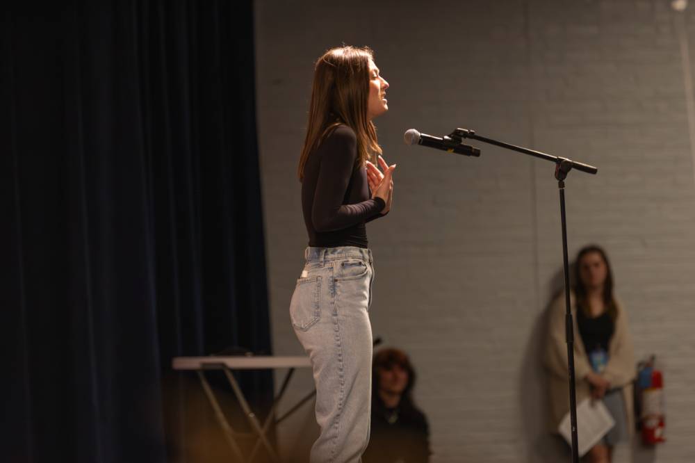 Ellen Kavanagh singing into a microphone stand on stage.